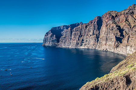 cliff near sea under blue sky at daytime thumbnail
