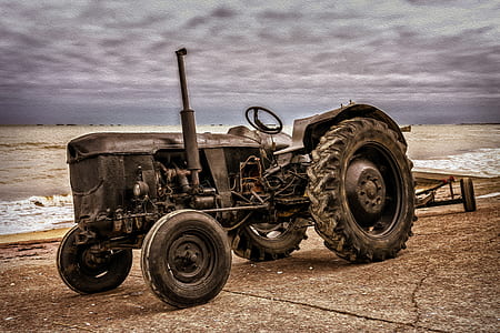black tractor parked under cloudy sky thumbnail