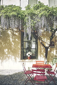 square red table with chairs outside beside white concrete building thumbnail