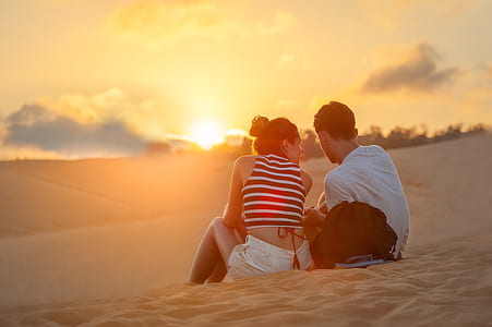 woman beside man sitting on sand thumbnail