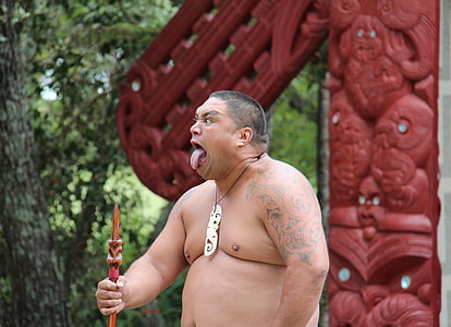 man showing his tongue and holding a stick during daytime thumbnail