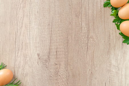 brown eggs on top of green leaf vegetables on wooden surface thumbnail
