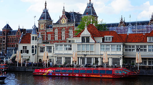 white and red castle beside the river with boat passing thumbnail