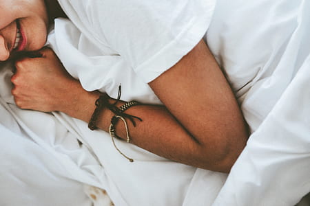 person lying on white textile thumbnail