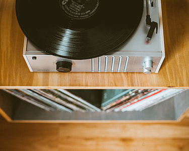 close view of grey vinyl record player on brown wooden desk thumbnail