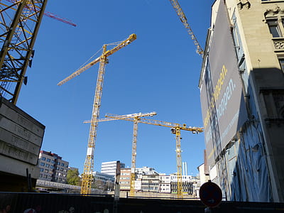 yellow tower cranes in the middle of the city thumbnail