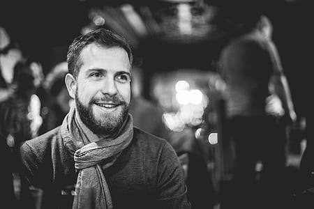 grayscale selective focus photography of man wearing scarf thumbnail