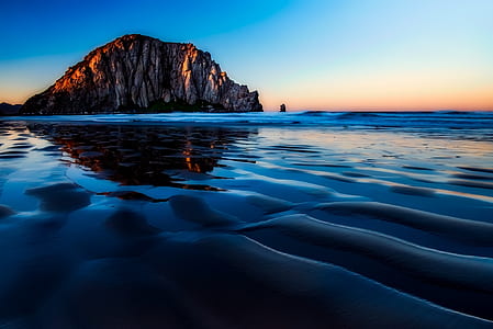 brown island near bodies of water photograph thumbnail