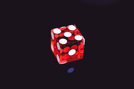 Red Translucent Die on Top of Black Surface thumbnail