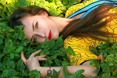 woman lying on the green leafed plants thumbnail