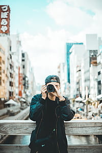 man holding camera standing near river thumbnail