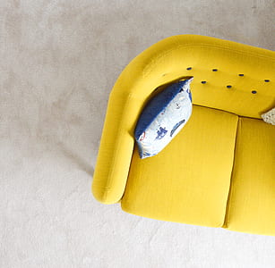 white and blue throw pillow on yellow sofa thumbnail