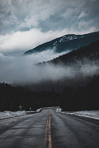 road towards mountain with fogs at daytime thumbnail