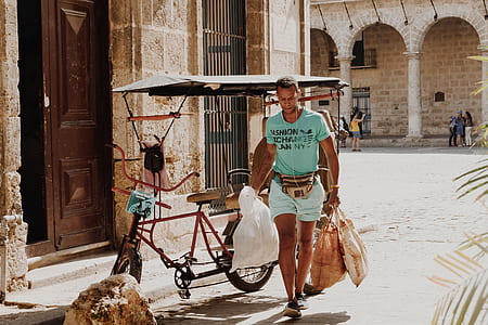 man wearing teal t-shirt carrying white plastic bag thumbnail