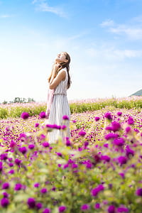 standing woman surrounded by purple flowers during daytime thumbnail