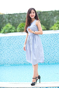 woman standing beside pool during daytime thumbnail