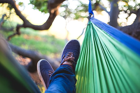 person lying on green and blue hammock thumbnail