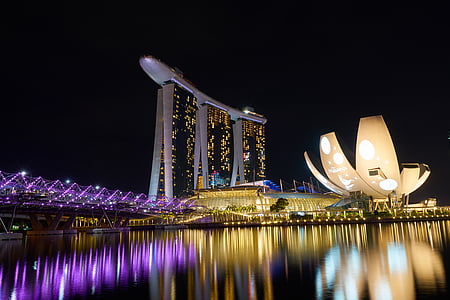 gray and black glass building beside body of water thumbnail