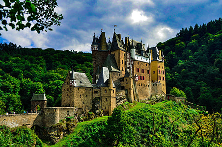 brown and black concrete castle near mountain during daytime thumbnail