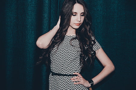 woman wearing white and black chevron dress standing against blue background thumbnail
