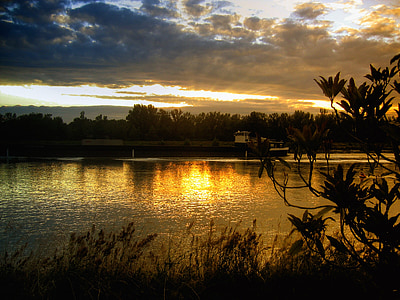 boat traveling on body of water during sunset thumbnail