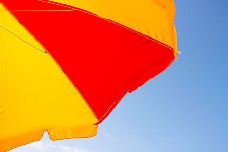 yellow and red umbrella under sunny sky thumbnail