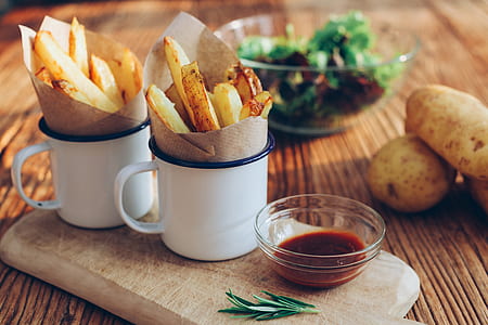 two mugs filled with French fries near bowl with sauce thumbnail
