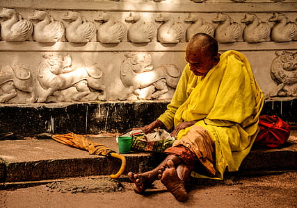 Man in Yellow Sitting Outside during Daytime thumbnail
