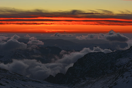 photo of cloudy sky over mountains during golden hour thumbnail