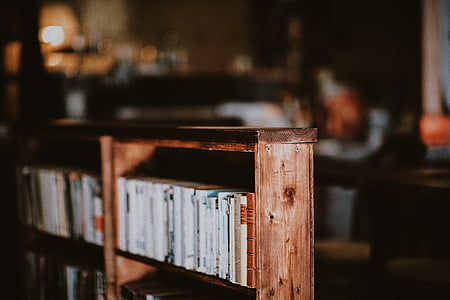 brown wooden bookcase with arranged books selective focus photography thumbnail