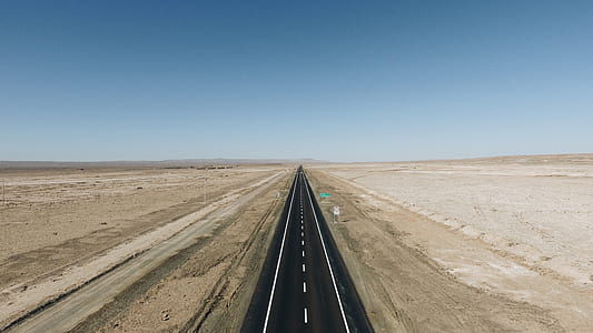 road between desert under blue sky thumbnail
