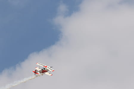 White and Red Biplane Flying during White Cloudy Day thumbnail
