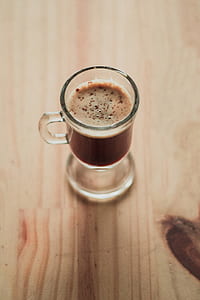 clear footed glass filled with capucino on desk thumbnail