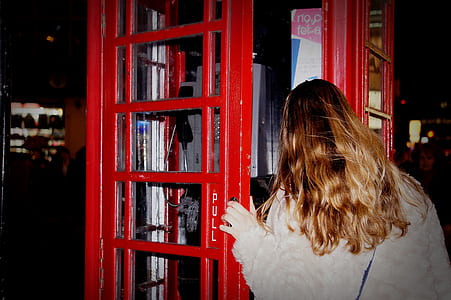 woman standing in front of red phone booth thumbnail