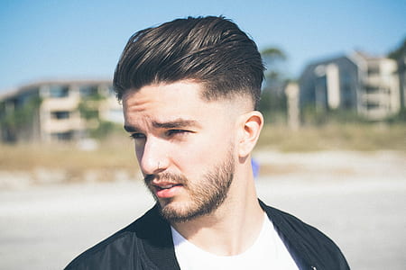 man in white crew-neck shirt and black cardigan thumbnail
