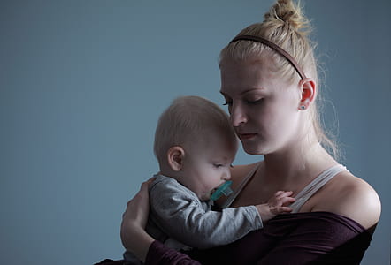 woman carrying baby inside room thumbnail