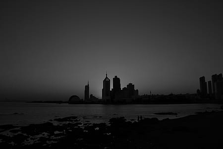 grayscale cityscape by water thumbnail