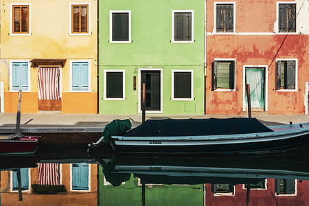 white outboard boat on body of water in front of houses thumbnail