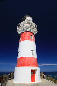 photo of people near white and red lighthouse thumbnail