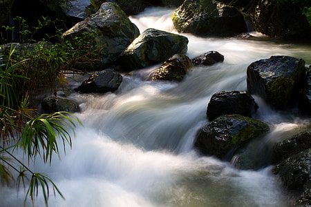 photo of body of water with black rocks thumbnail