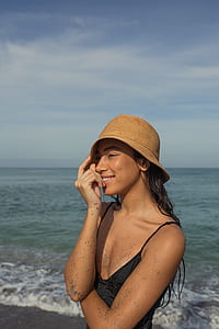 woman standing on seashore during daytime thumbnail
