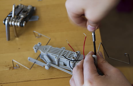 person repairing gray toy thumbnail