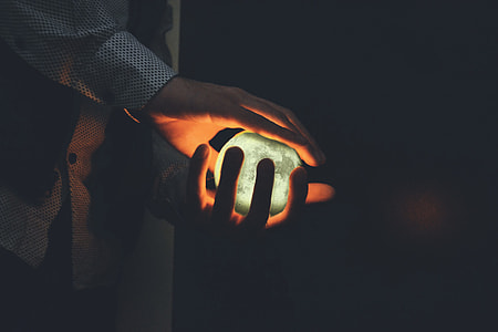 Closeup shot of a man’s hands holding a glowing orb thumbnail