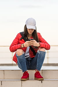 woman sitting on stair holding smartphone thumbnail
