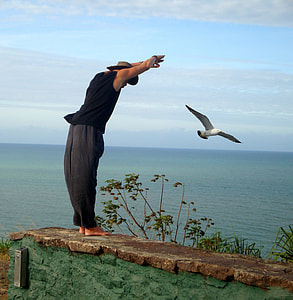man in black sleeveless top and grey pants standing on grey concrete pavement thumbnail