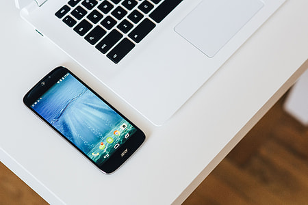 White laptop with smartphone and headphones thumbnail