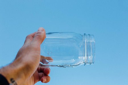 person holding clear glass mason jar thumbnail
