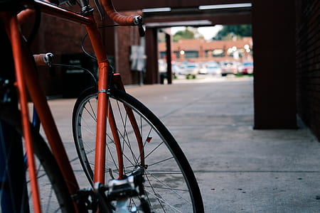 red and black bicycle park beside wall thumbnail