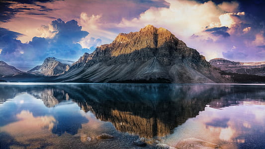 calm body of water near mountain at daytime thumbnail