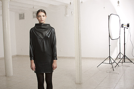 woman in black leather long-sleeve shirt and black pants near on stage light thumbnail